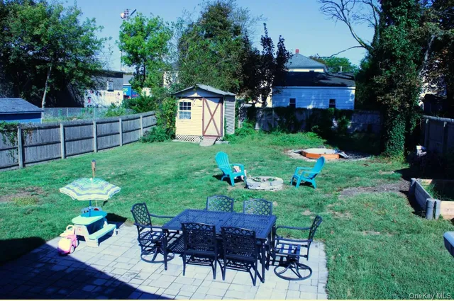 a view of a backyard with table and chairs potted plants and wooden fence
