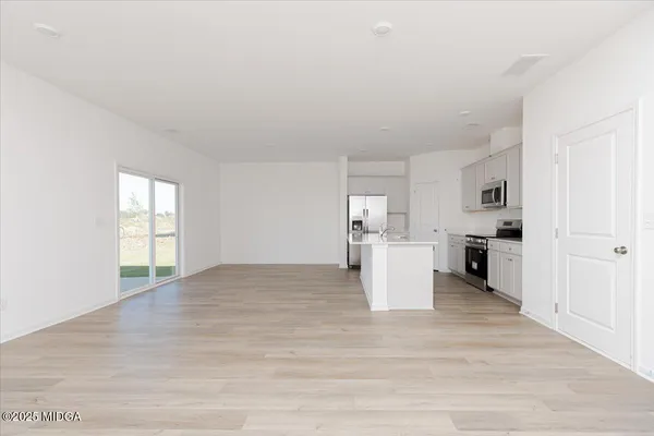 a view of a kitchen with wooden floor and electronic appliances