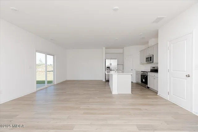 a view of a kitchen with wooden floor and electronic appliances