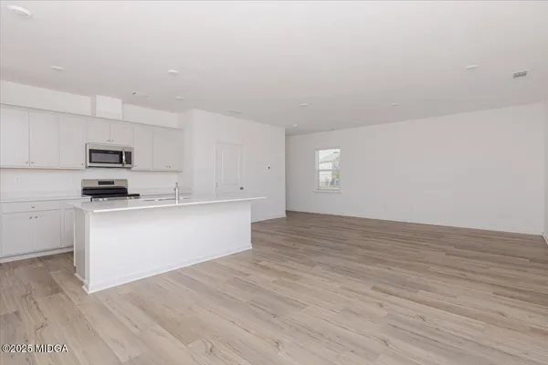 a view of kitchen with wooden floor and electronic appliances