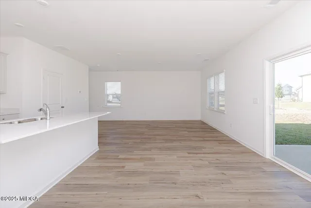 a view of a kitchen with wooden floor and a sink