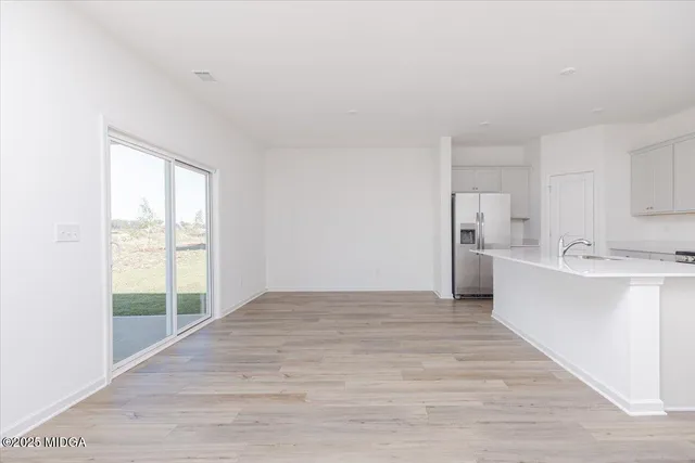 a view of a kitchen with wooden floor and a sink