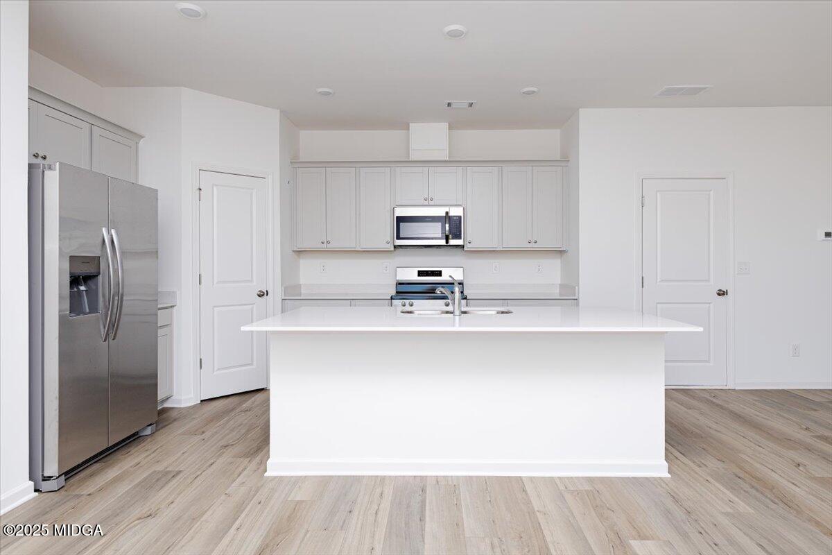 218 Hickory Rdg Trail Kathleen, GA 31047 - Photo 18 of 48 a kitchen with stainless steel appliances a sink a refrigerator and wooden floor