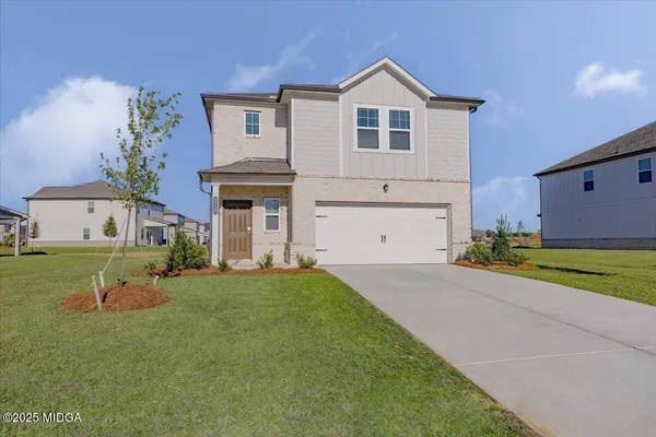 a front view of a house with a yard and garage