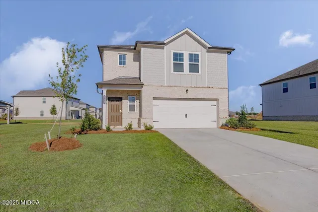 a front view of a house with a yard and garage