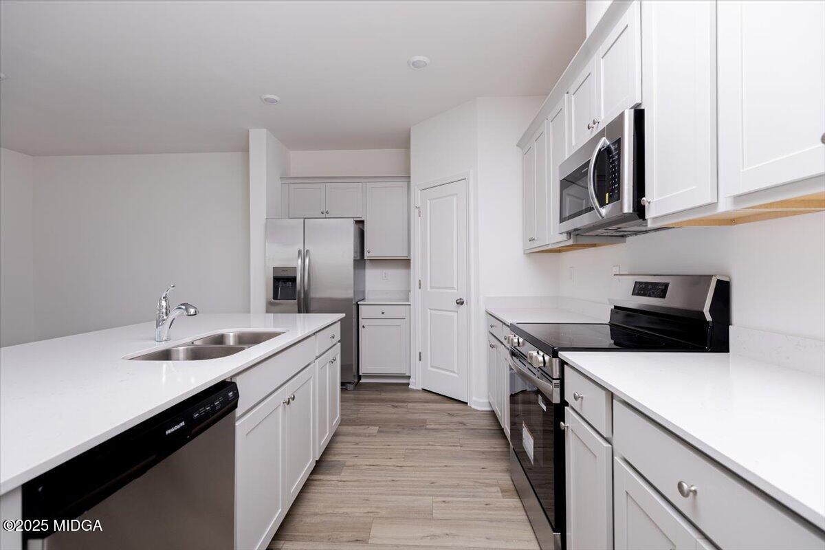 218 Hickory Rdg Trail Kathleen, GA 31047 - Photo 21 of 48 a kitchen with stainless steel appliances a sink stove oven a refrigerator with white cabinets and wooden floor