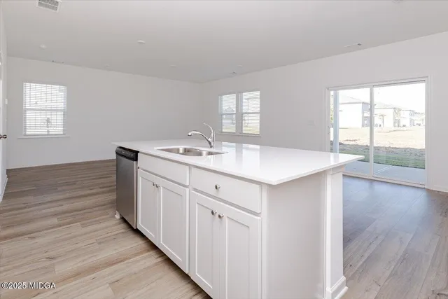 a kitchen with a sink cabinets and wooden floor