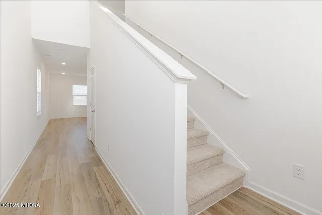 a view of a hallway with wooden floor and staircase