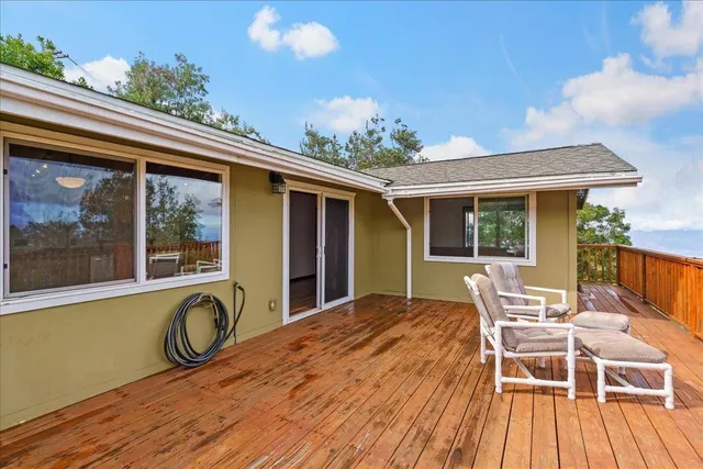 a view of a patio with table and chairs a barbeque with wooden floor and fence