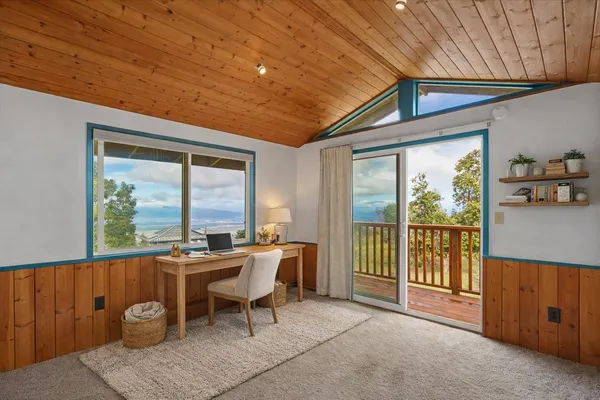 a dining room with furniture and a floor to ceiling window