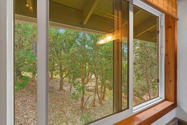 a view of a room with a large window and wooden floor