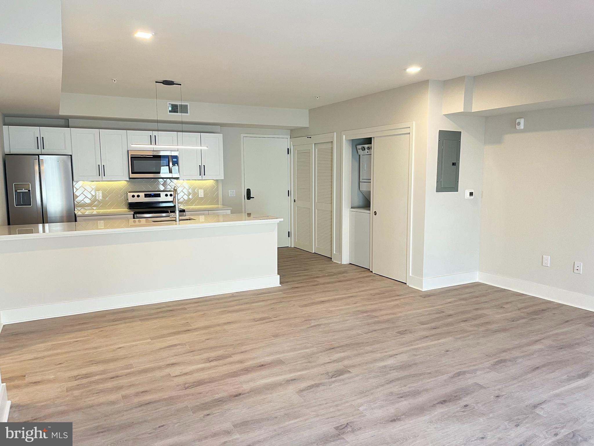 1805 North Howard Street, Unit 303 Philadelphia, PA 19122 - Photo 13 of 25 a large kitchen with stainless steel appliances a large counter top a stove and a refrigerator