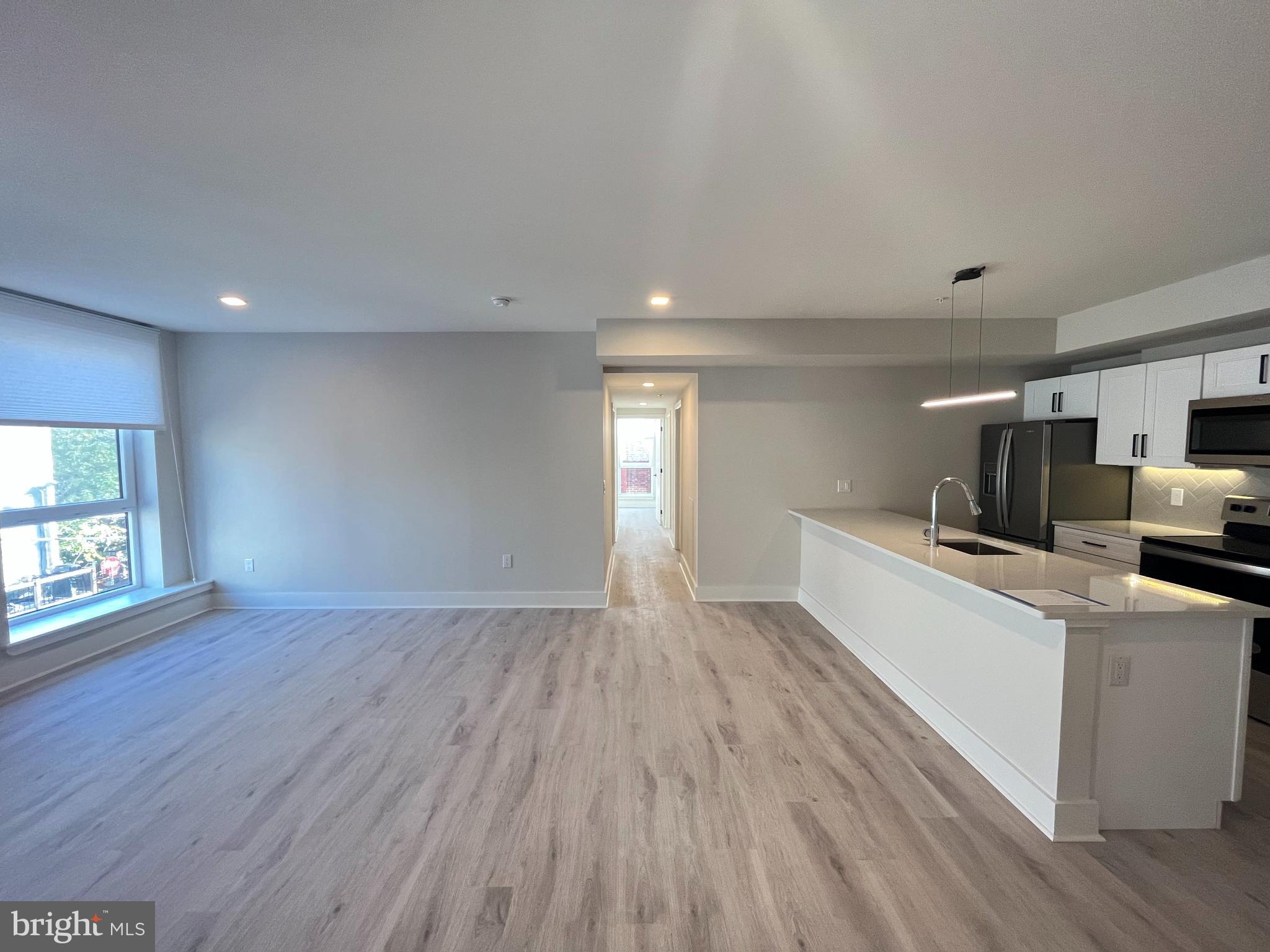 1805 North Howard Street, Unit 303 Philadelphia, PA 19122 - Photo 15 of 25 a view of open kitchen with wooden floor and electronic appliances