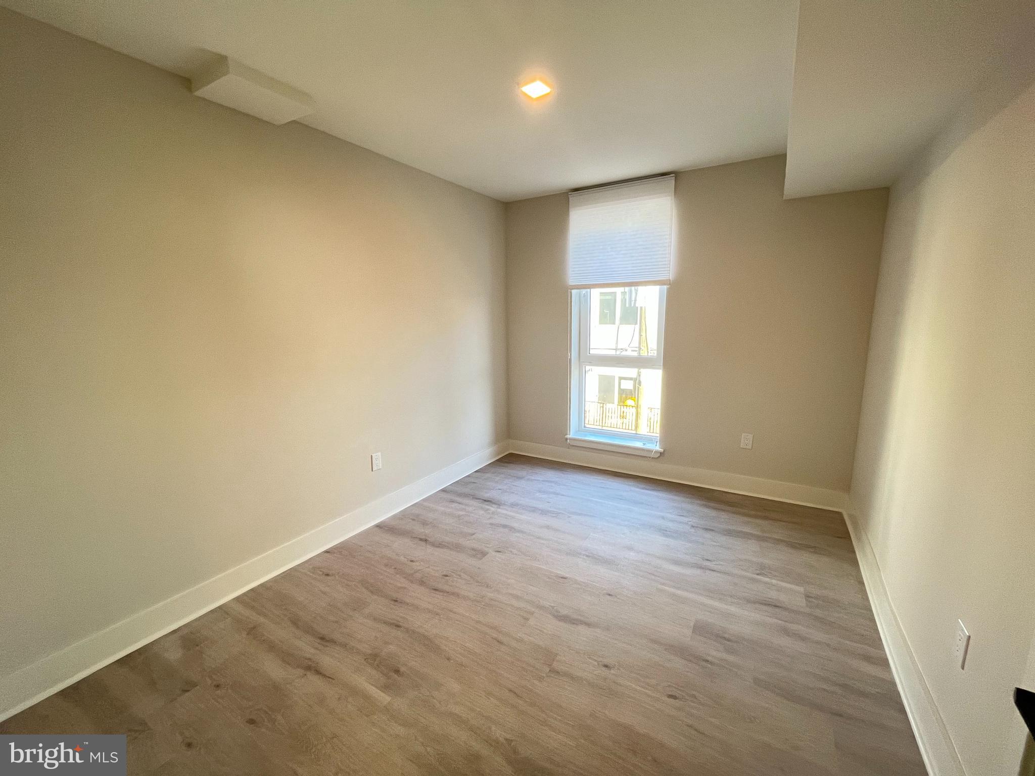 1805 North Howard Street, Unit 303 Philadelphia, PA 19122 - Photo 16 of 25 an empty room with wooden floor and windows
