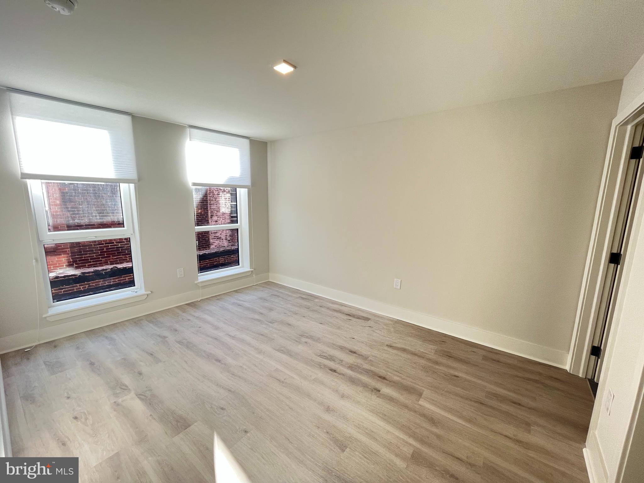 1805 North Howard Street, Unit 303 Philadelphia, PA 19122 - Photo 18 of 25 an empty room with wooden floor and windows
