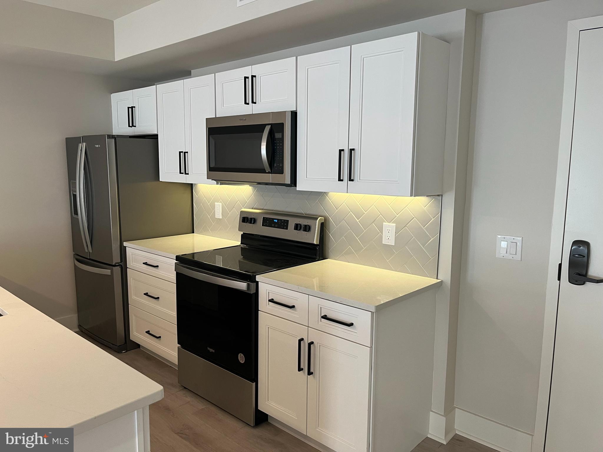 1805 North Howard Street, Unit 303 Philadelphia, PA 19122 - Photo 3 of 25 a kitchen with white cabinets and stainless steel appliances