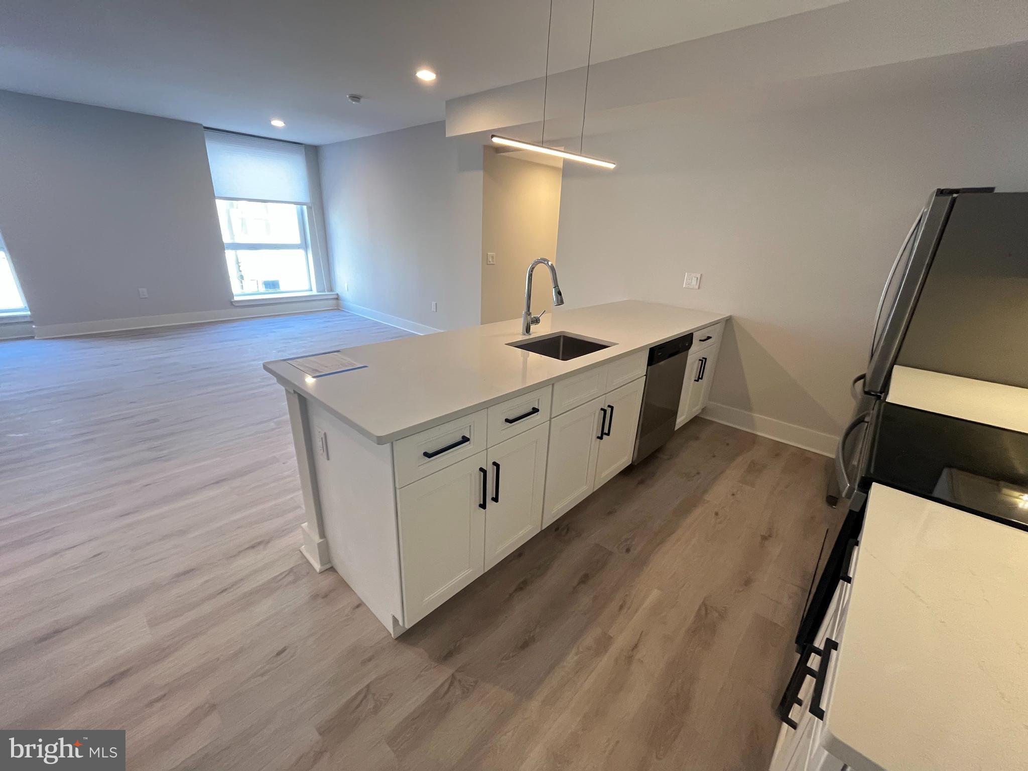 1805 North Howard Street, Unit 303 Philadelphia, PA 19122 - Photo 8 of 25 a kitchen with sink microwave and stove