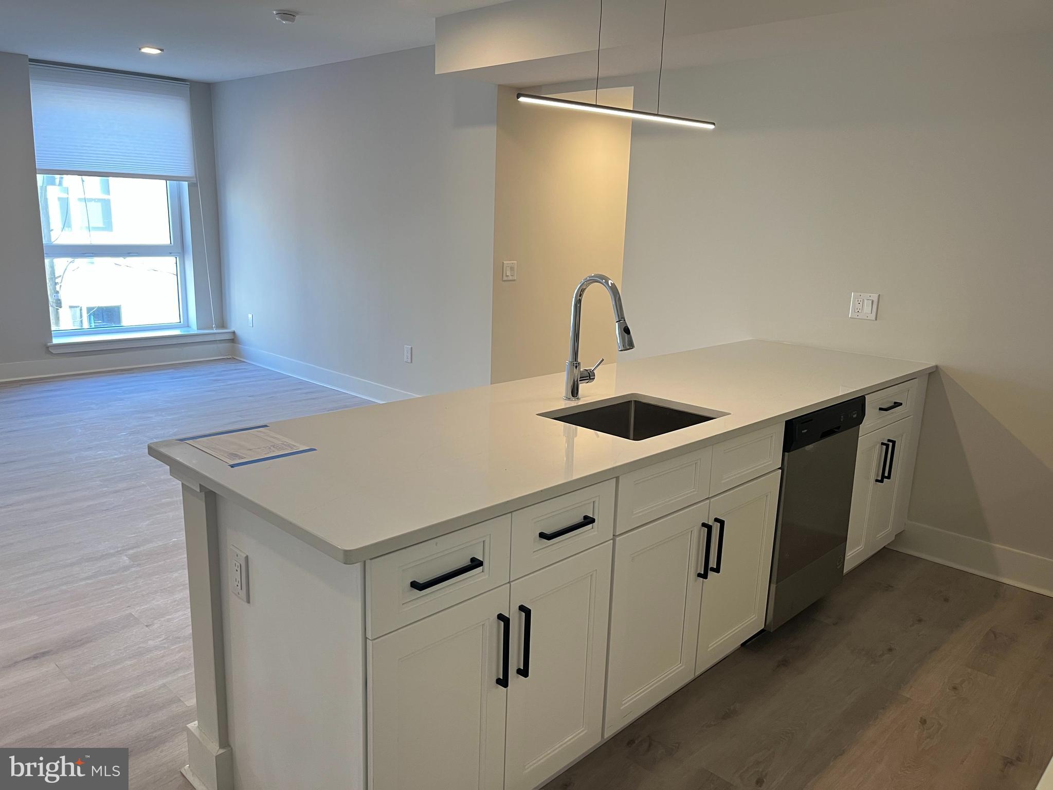 1805 North Howard Street, Unit 303 Philadelphia, PA 19122 - Photo 9 of 25 a kitchen with white cabinets appliances and window