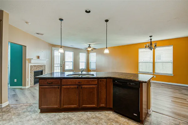 a kitchen with stainless steel appliances granite countertop a sink a counter space and a view of living room