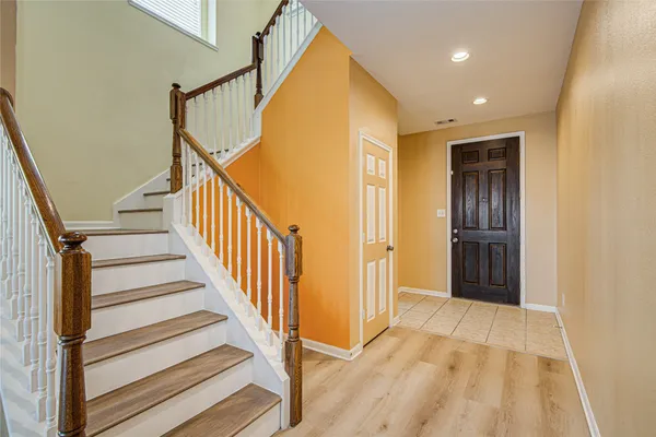 a view of a hallway with wooden floor and entryway
