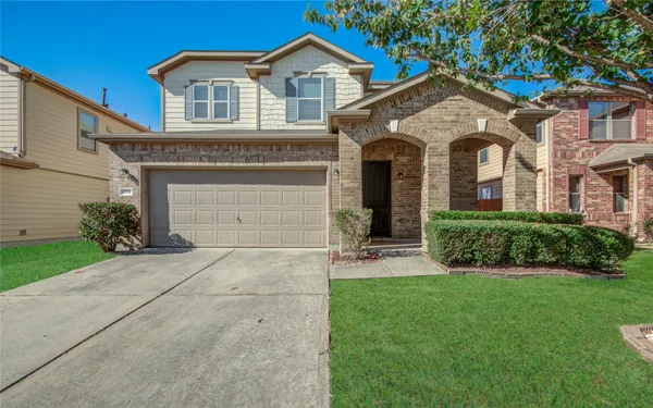 a front view of a house with a yard and garage