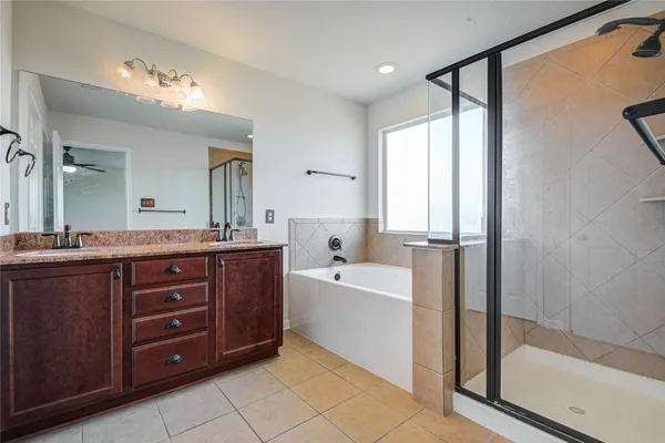 a spacious bathroom with a tub sink shower and mirror