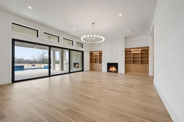 a view of an empty room with a fireplace and a window