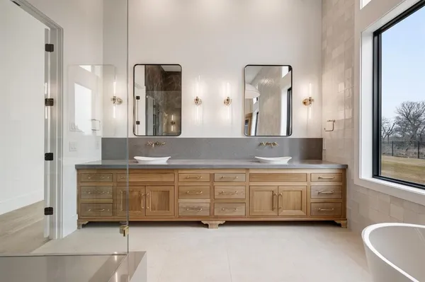 a spacious bathroom with a double vanity sink a mirror and a bathtub