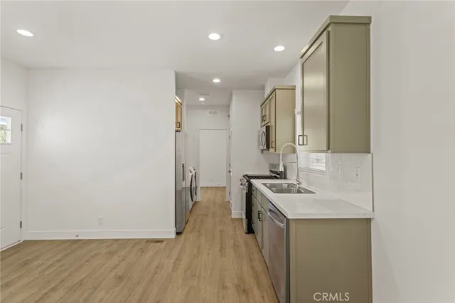 a kitchen with granite countertop white cabinets and stainless steel appliances