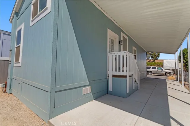 a view of a white house with a yard porch and sitting area