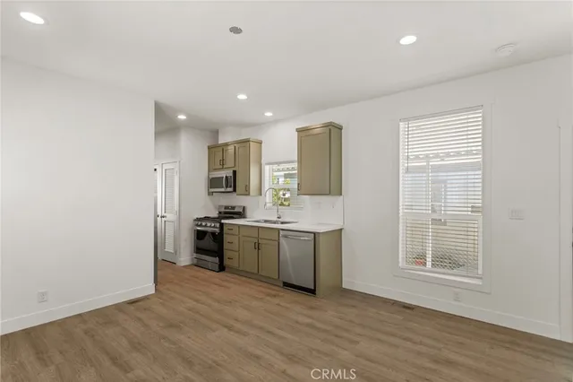 a view of a kitchen with white cabinets and wooden floor