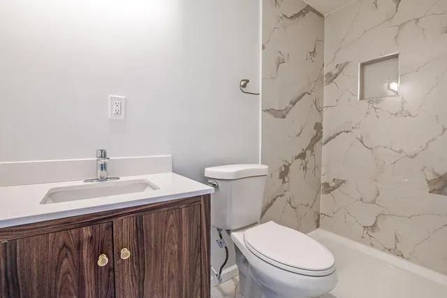 a white toilet sitting next to a bathroom sink