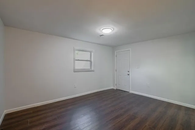 a view of a room with wooden floor and white walls