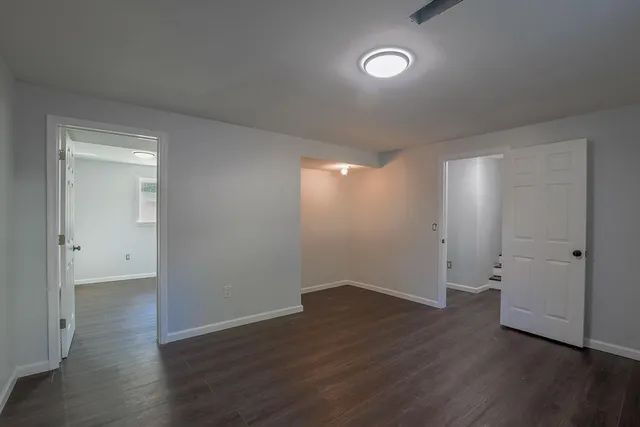 a view of an empty room with wooden floor