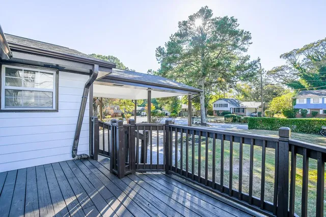 a view of a wooden deck with large trees