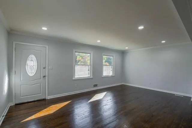 an empty room with wooden floor and window
