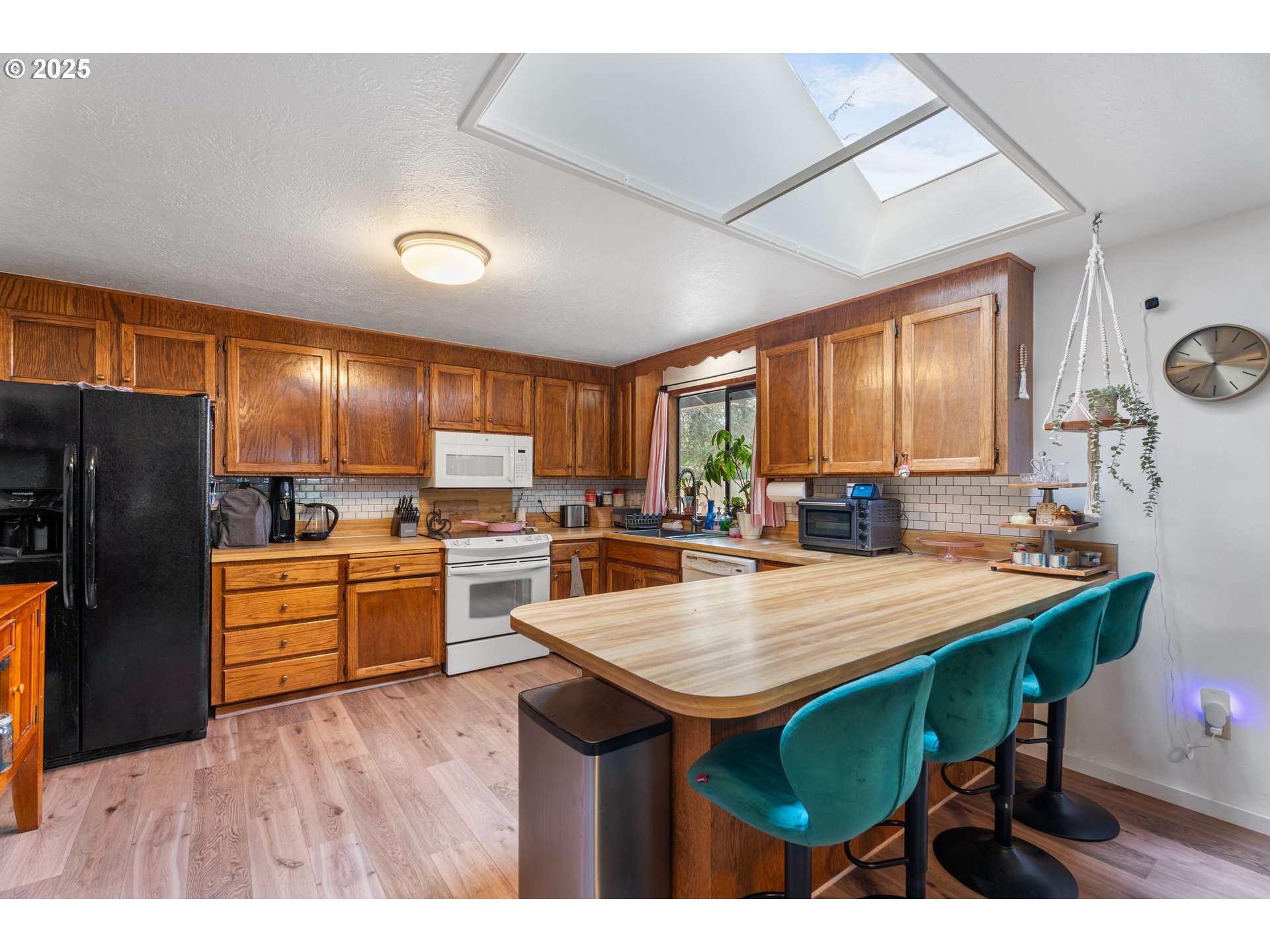 2356 B Street Hubbard, OR 97032 - Photo 14 of 32 a kitchen with stainless steel appliances kitchen island granite countertop a table chairs and a refrigerator