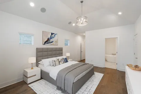 a bedroom with a large bed and a chandelier