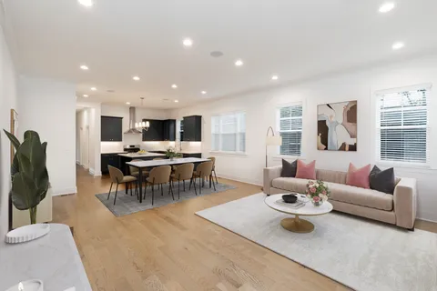 a living room with lots of furniture and view of kitchen