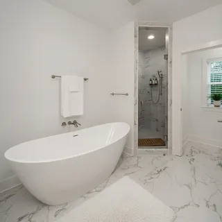 a white bath tub sitting in a bathroom and shower