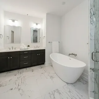 a spacious bathroom with a tub sink and mirror