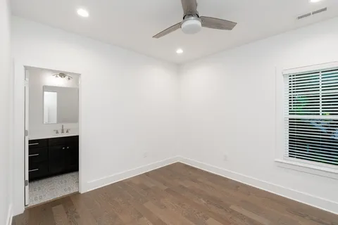an empty room with wooden floor and bathroom