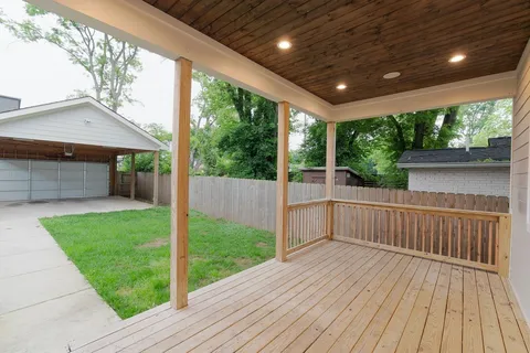 a view of a porch with wooden floor and yard