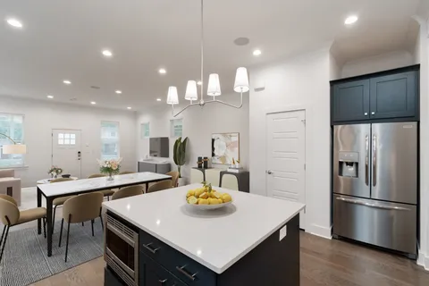 a kitchen with stainless steel appliances a table chairs and kitchen