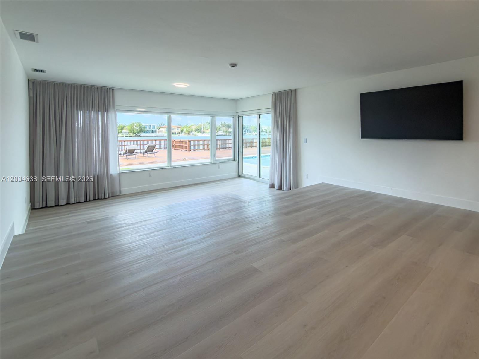 1690 Daytonia Road Miami Beach, FL 33141 - Photo 18 of 88 a view of an empty room with wooden floor and a window