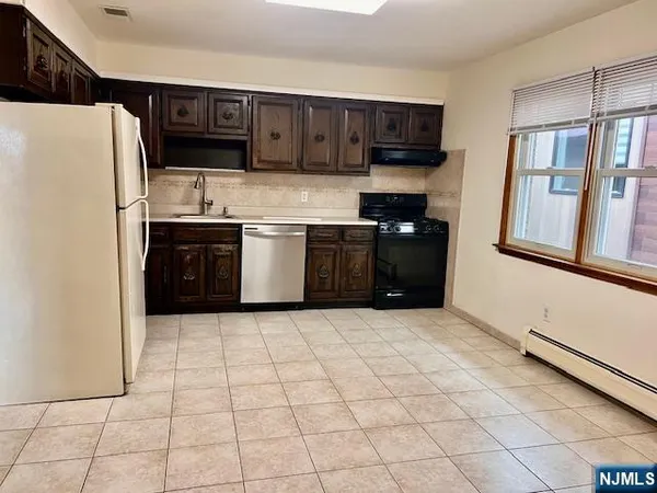 a kitchen with stainless steel appliances granite countertop a refrigerator stove top oven and a sink