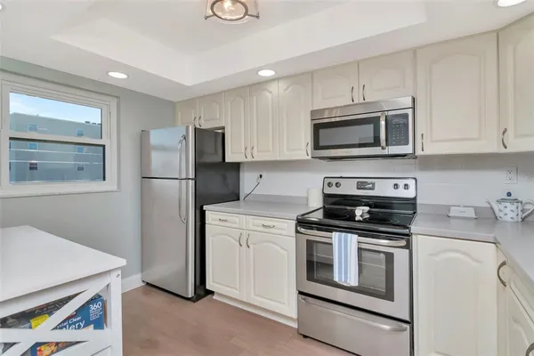 a kitchen with granite countertop white cabinets sink and stainless steel appliances