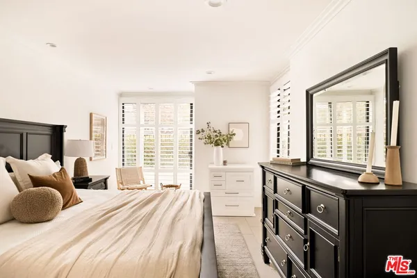 a bedroom with a bed and a large window