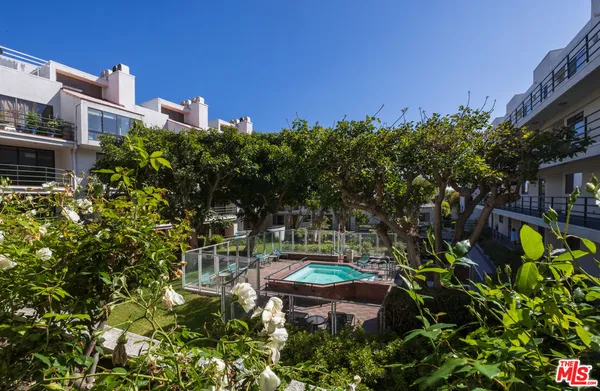 a backyard of a house with lots of green space and fountain in the back