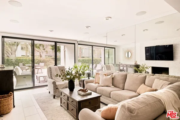 a living room with furniture a flat screen tv and a floor to ceiling window